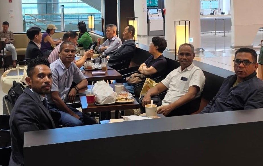 Embassy protocol officer coordinating with the delegation at the airport lounge
