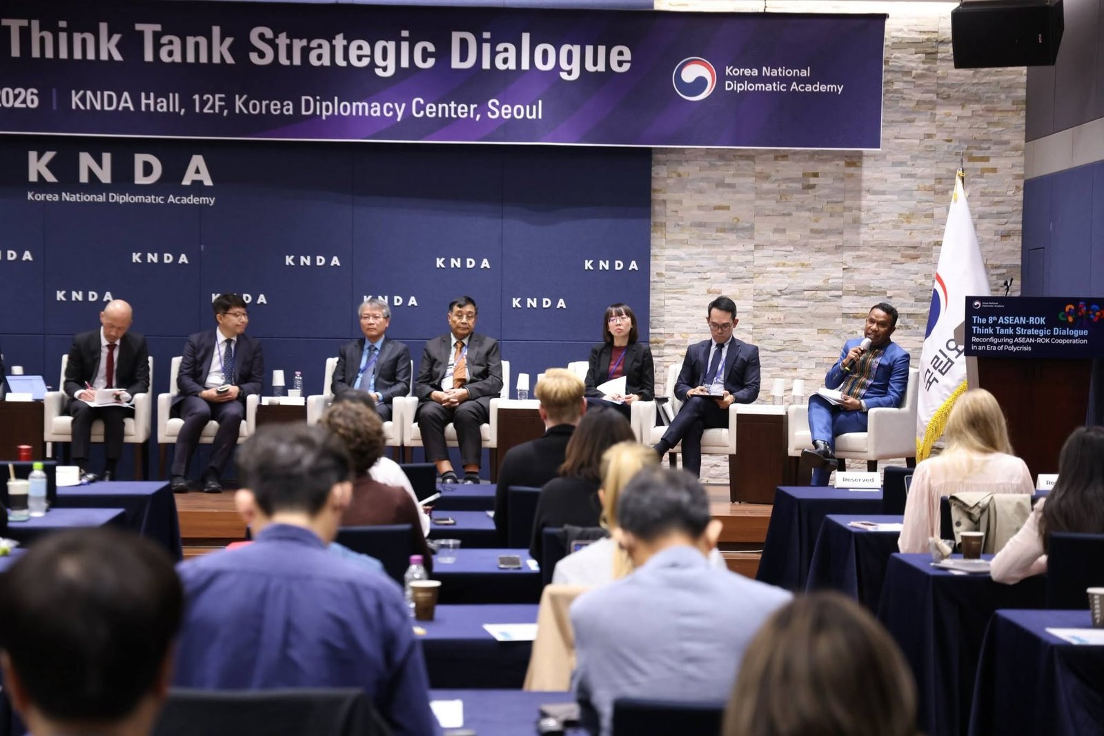 Stage panel presenting to academics and scholars